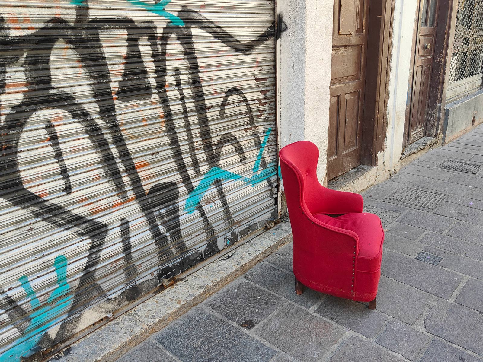 Roter Polstersessel vor Garagentor mit Graffito